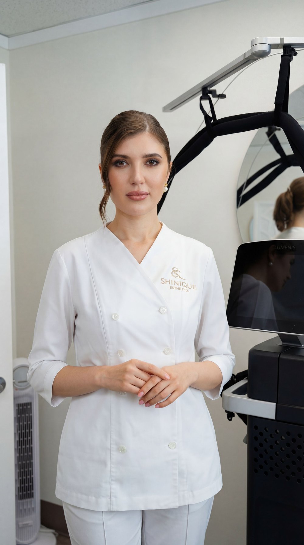 Viktoriia Boiko in her Shinique Esthetics uniform beside a Lumenis laser system